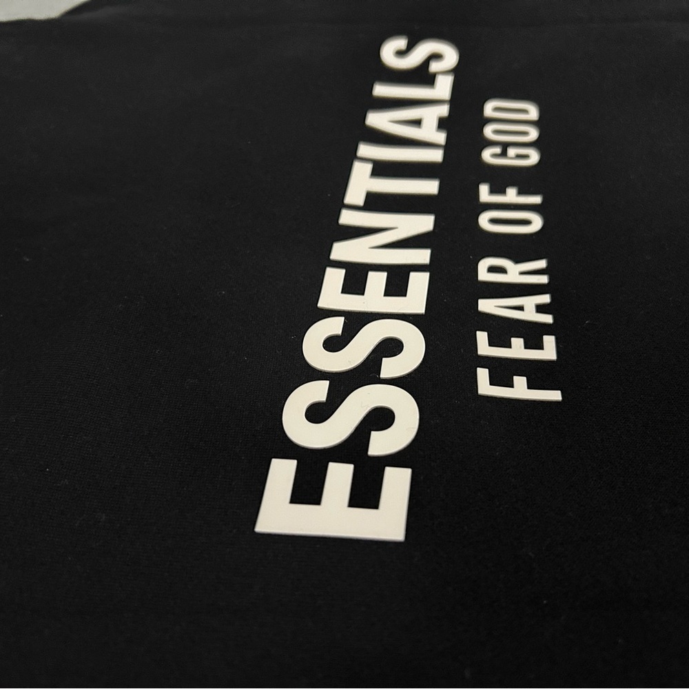 Fear of God Essentials Black Tee with White Care Tag Print